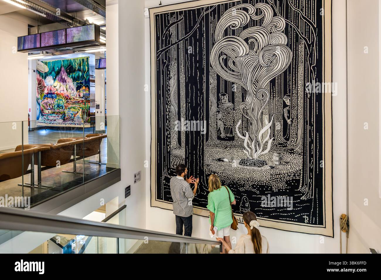Guided tour of the exhibition rooms at the Cité internationale de la tapisserie Aubusson. Here, in front of a motif from "The Hobbits" based on an illustration by J.R.R. Tolkien. Created in 2019 by the Guillot workshop in Aubusson, 3 metres x 4 metres. Rue Williams Dumazet, Aubusson, Nouvelle-Aquitaine, France Stock Photo