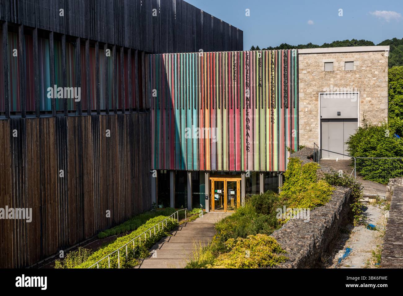 The striking building with the colourful façade of the Cité internationale de la tapisserie in Aubusson. The institution is a model project that preserves the traditional expertise of a UNESCO-recognised cultural technique, leads it into the future through targeted innovation and positions itself in an international network. Avenue de la République, Aubusson, Nouvelle-Aquitaine, France Stock Photo
