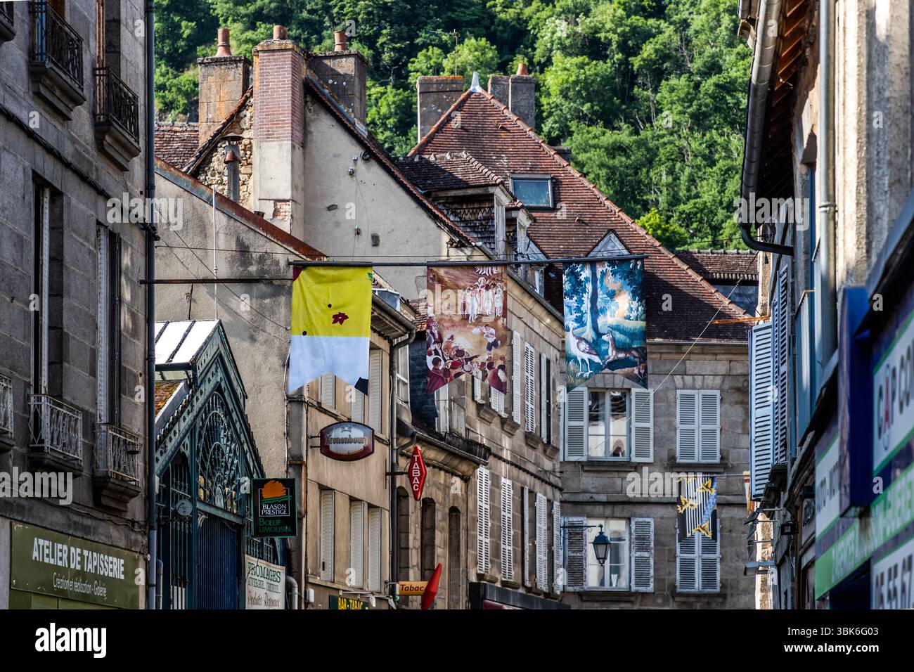 Main street of Aubusson decorated with street art commemorating the history of tapestry in the region. Recognised as intangible cultural heritage by UNESCO in 2009, Aubusson tapestry embodies over 600 years of fine craftsmanship and artistic design, which is still practised and developed today. Place Jean Lurçat, Aubusson, Nouvelle-Aquitaine, France Stock Photo