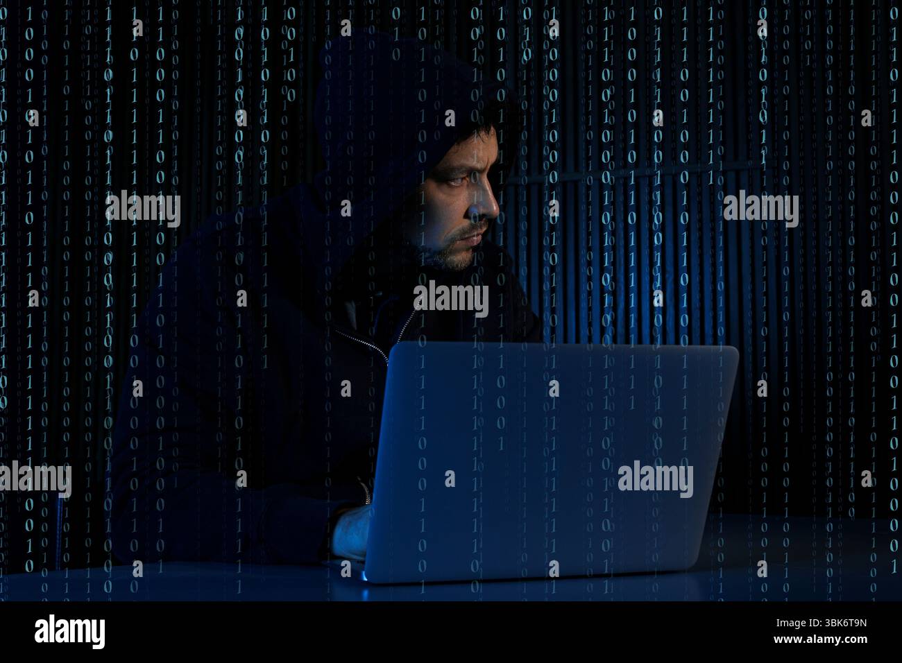 Cyber attack. Hacker working on laptop against dark background. Binary code around him Stock Photo