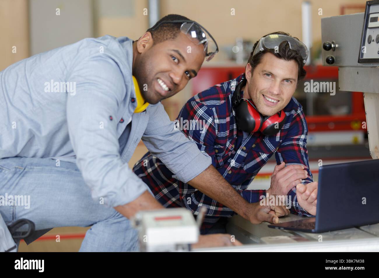 two modern mechanics using a laptop Stock Photo