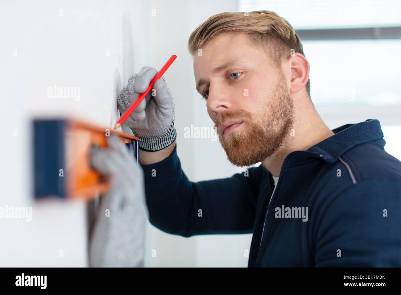 construction worker using spirit level and pencil Stock Photo