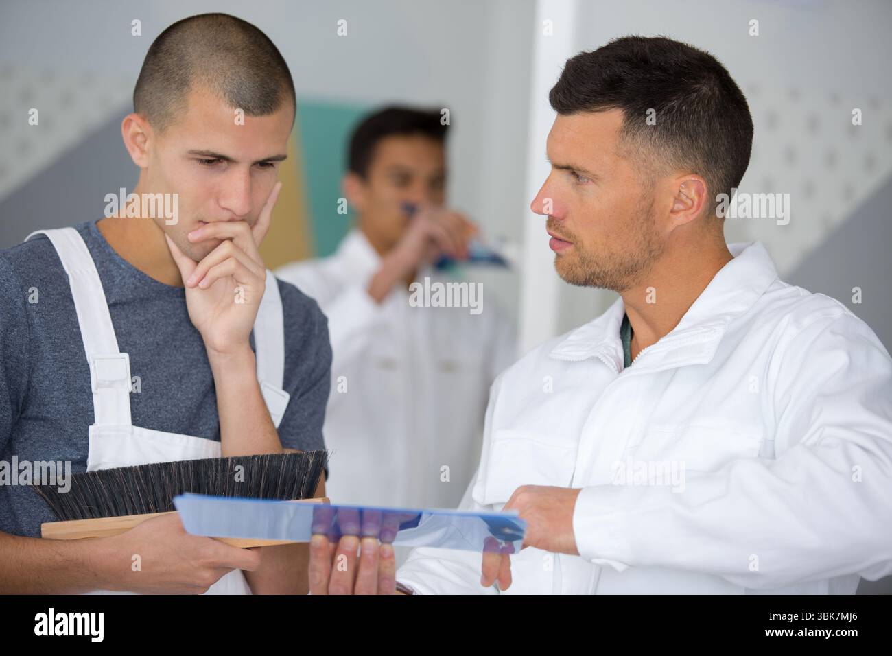 apprentices learning how to paint with a thick brush Stock Photo