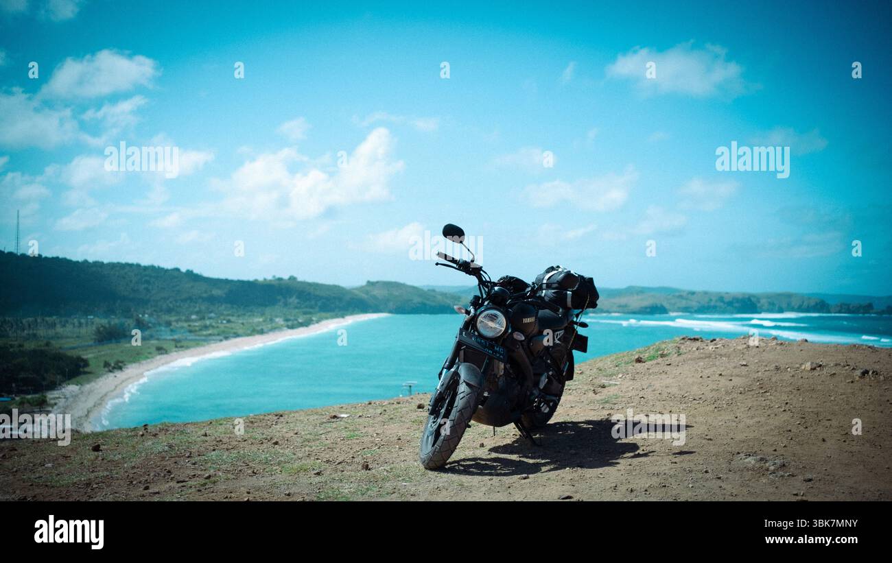 Motorbike Parked on Coastal Cliff Overlooking the Ocean in Lombok, Indonesia Stock Photo