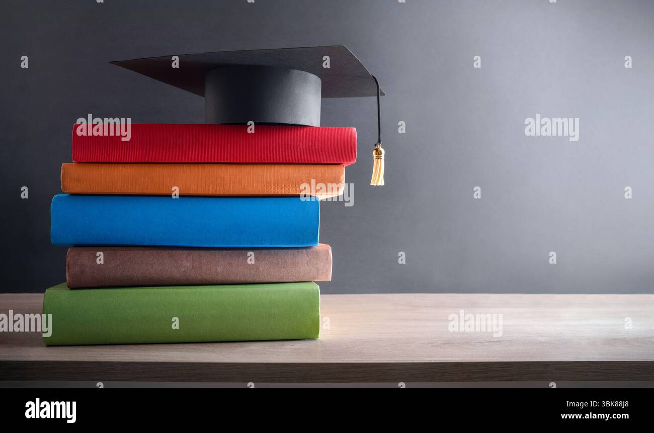 Graduation and education concept with mortarboard on stack of books ...
