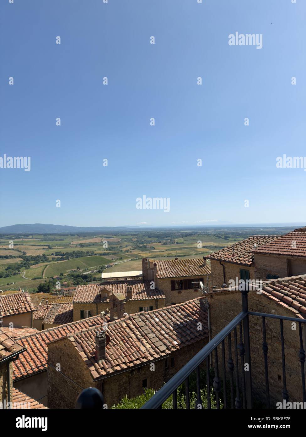 view of red tiled roofs against the backdrop of the picturesque Tuscan landscape, Italy, travel theme - Smartphone Captured Stock Image