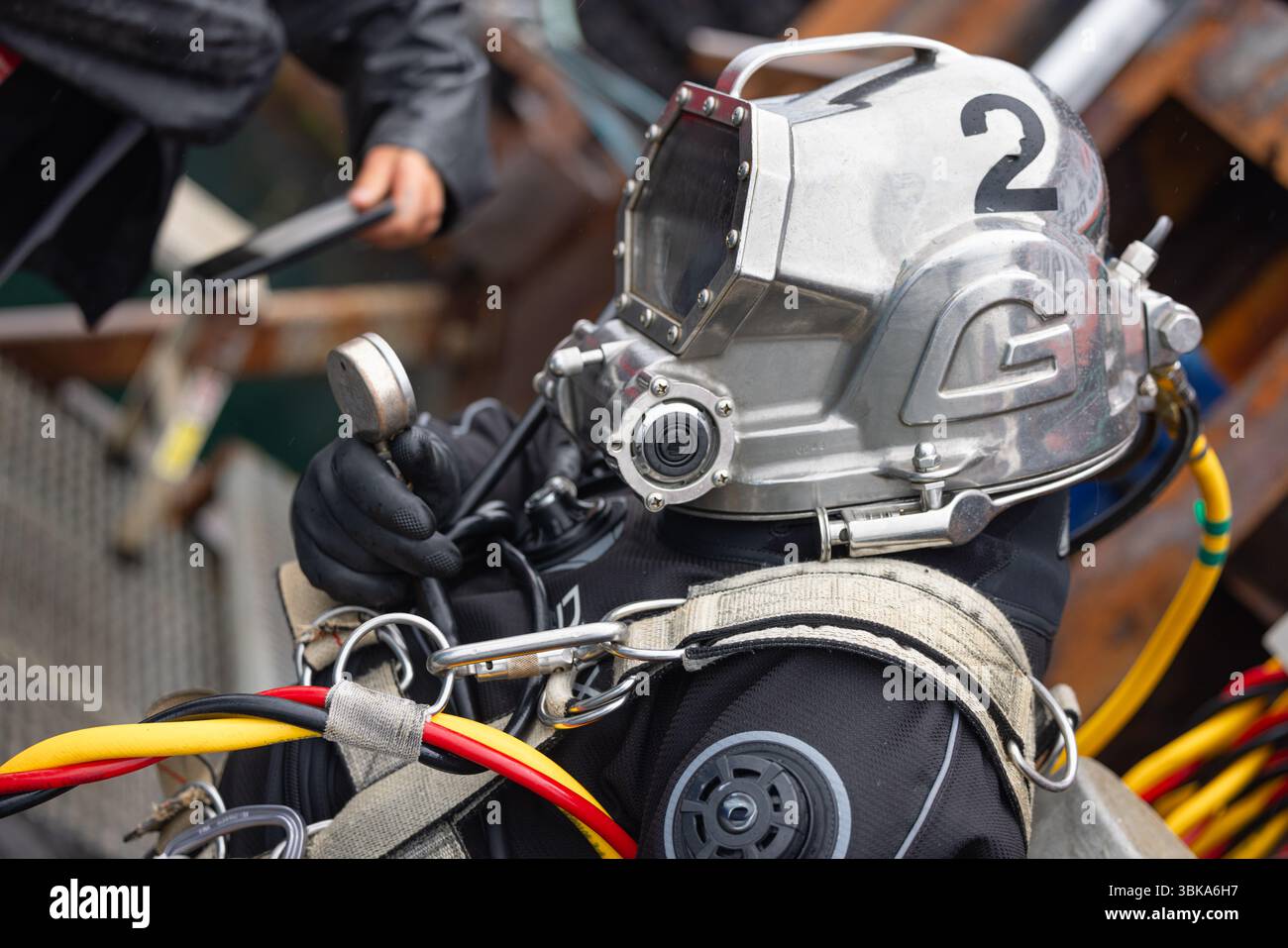 Commercial diver in helmet prepares for dive closeup Stock Photo - Alamy