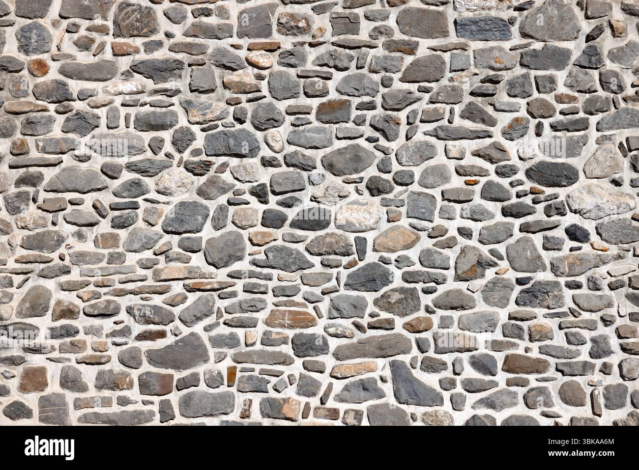 Wall constructed with various natural stones as background Stock Photo