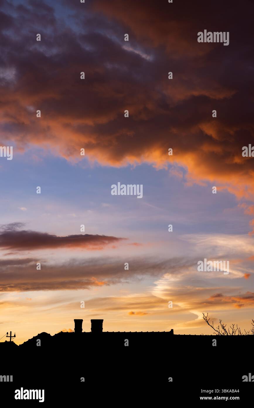 Dramatic sky with orange and dark clouds after storm Stock Photo