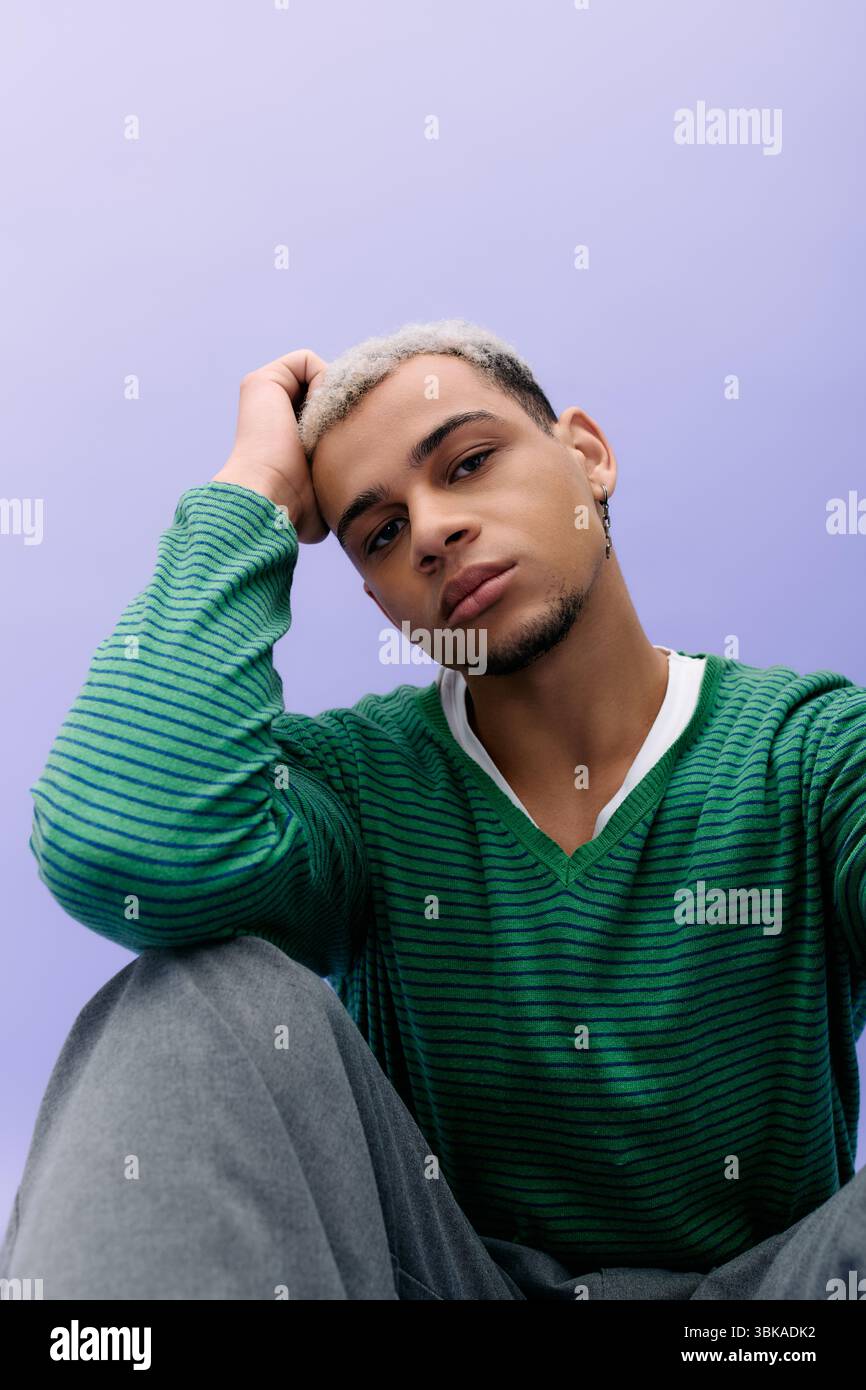 A young African American man poses confidently while showing off his ...