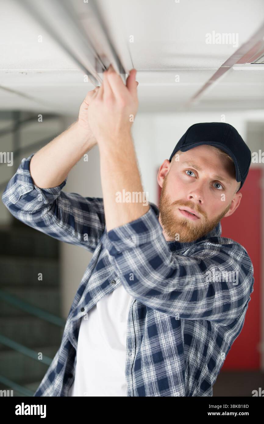 young guy repairs ceiling Stock Photo