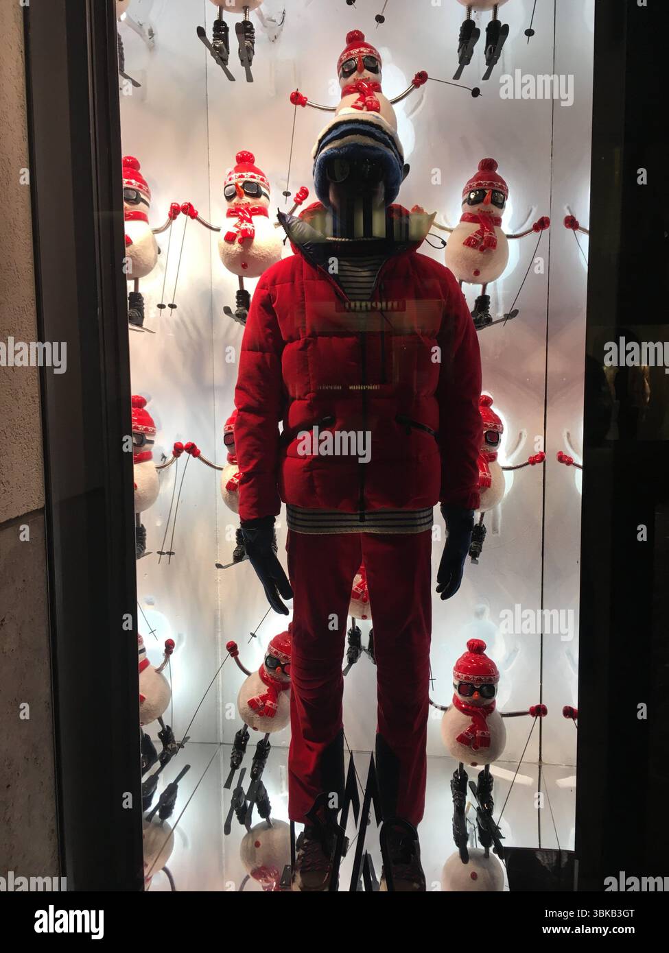 Hamburg storefront displays premium skiing apparel—jackets, pants, goggles—artfully arranged with alpine visuals and subtle lighting, inviting winter Stock Photo