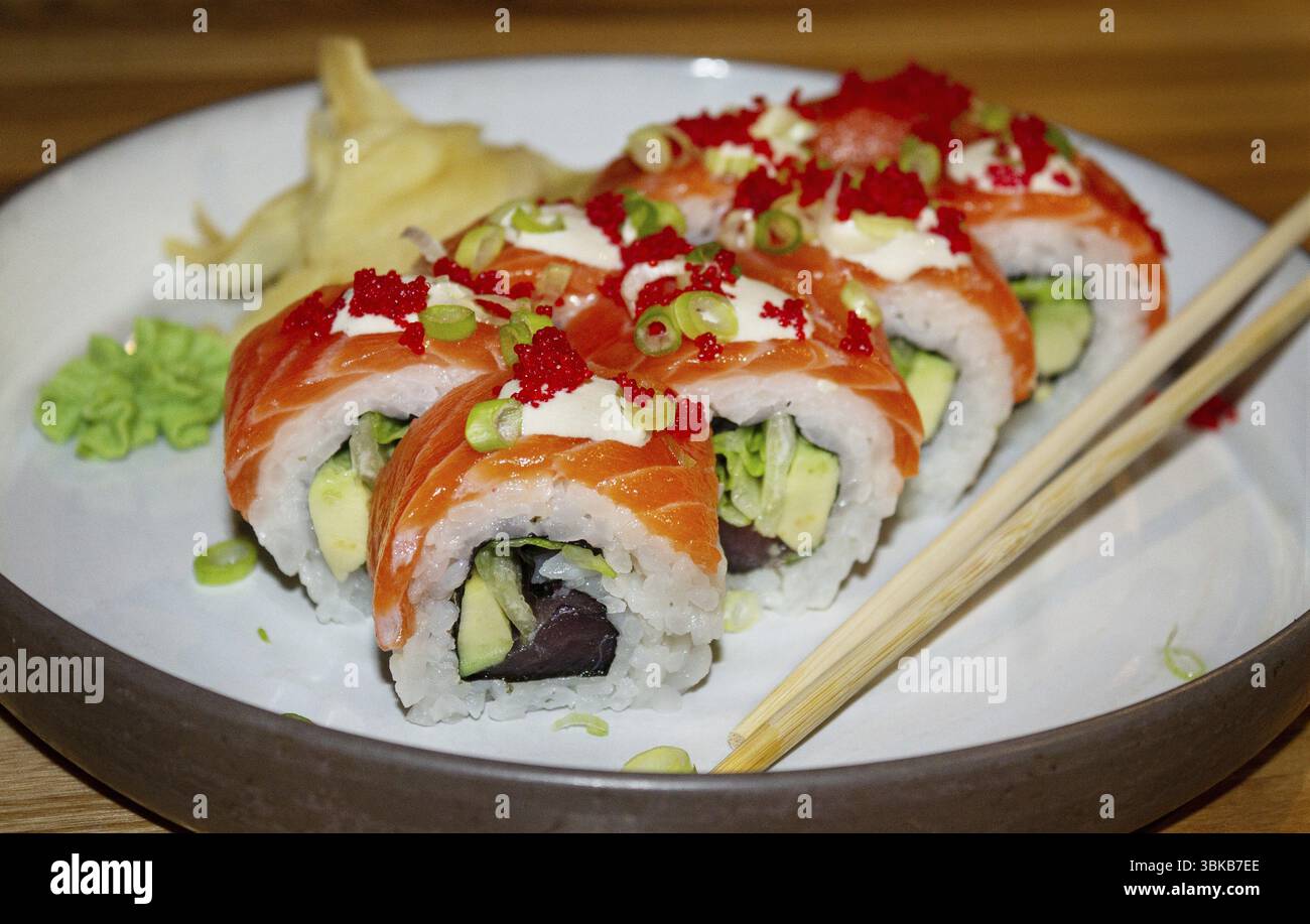 Plate with salmon rolls and wooden sticks, on the table, japanese cuisine Stock Photo