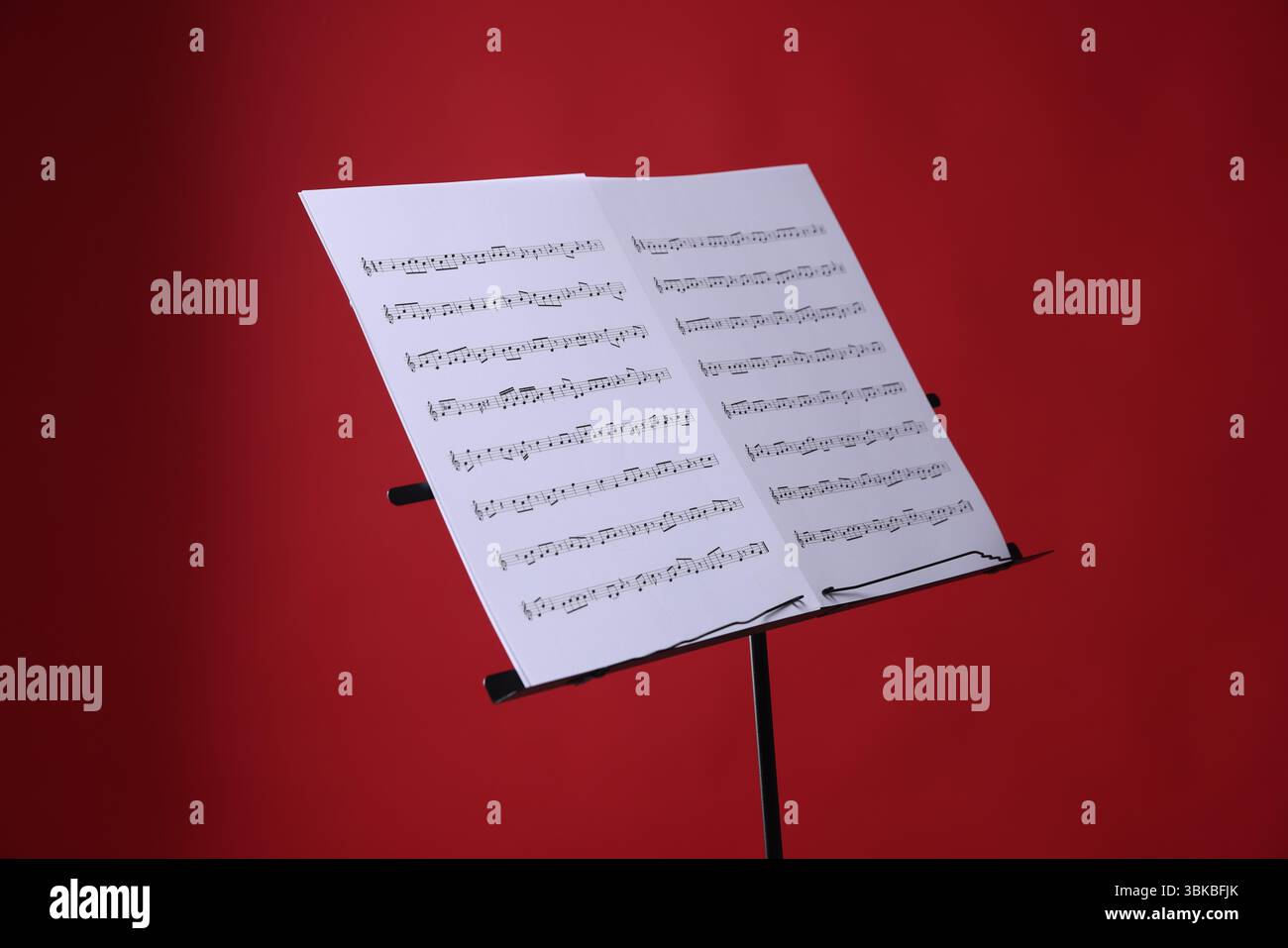 Note stand with music sheets on red background Stock Photo