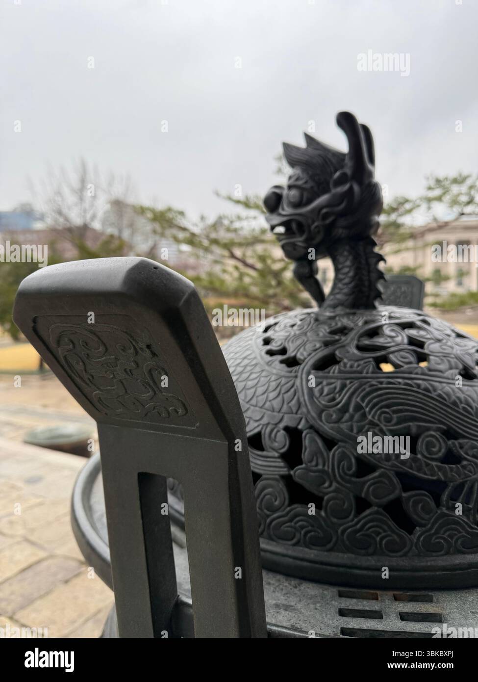 Intricate dragon carvings adorn a traditional Korean incense burner, symbolizing strength and protection in royal and spiritual settings. - Smartphone Captured Stock Image