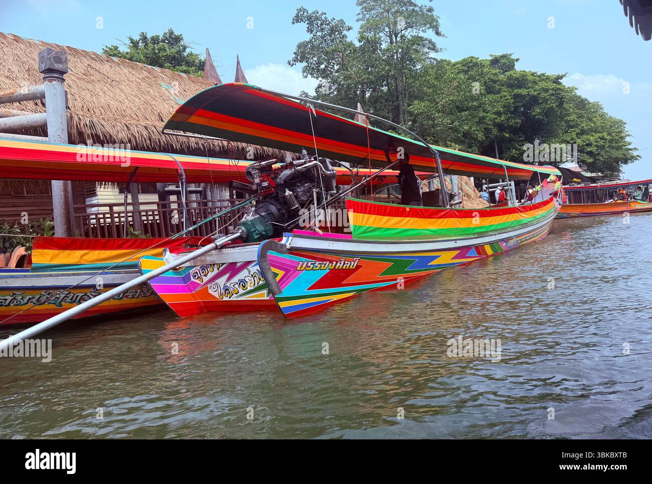 Colorful longtail boats line the dock in Thailand, showcasing the country’s vibrant river culture and traditional waterway transport. - Smartphone Captured Stock Image