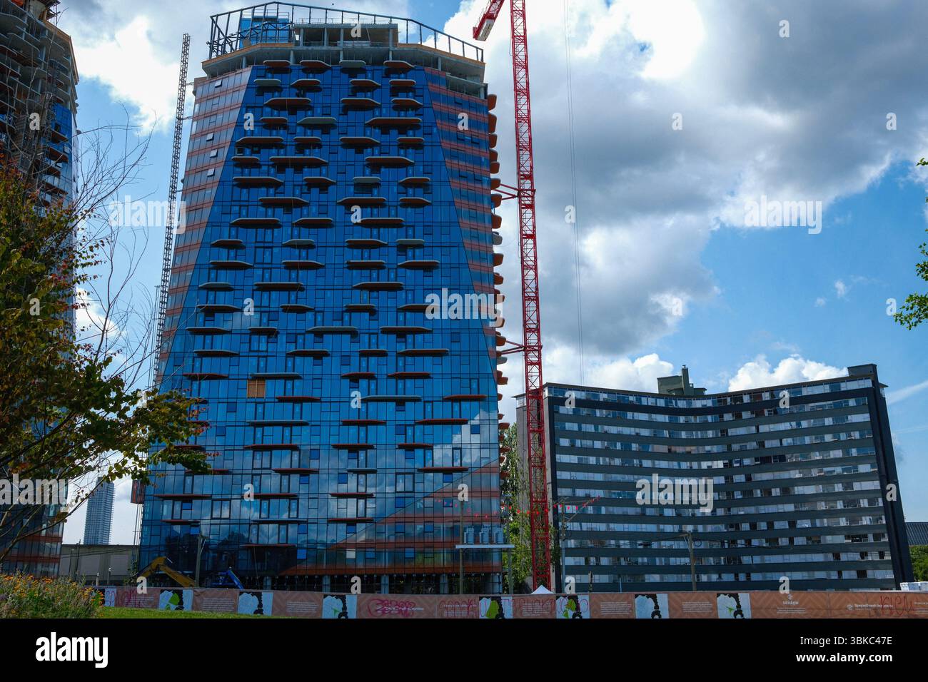 A red crane stands alongside the new Sen̓áḵw development with the ...
