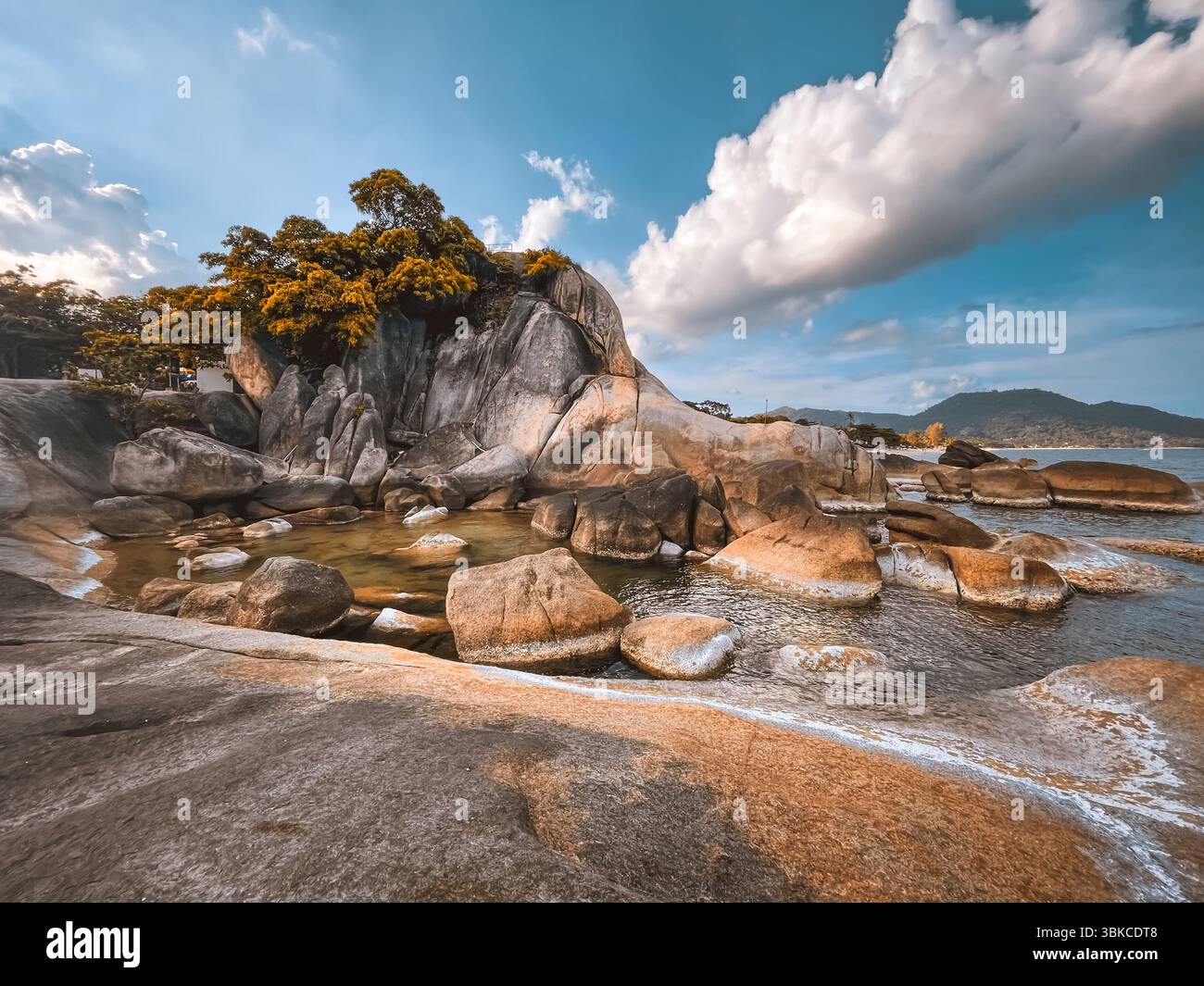 Grandfather and Grandmother Rocks Hin Ta Hin Yai on Koh Samui island, Thailand. Orange stones in water, blue cloudy sky. Incredible seascape scene, mountain landscape. Travel, tourism, holiday Stock Photo