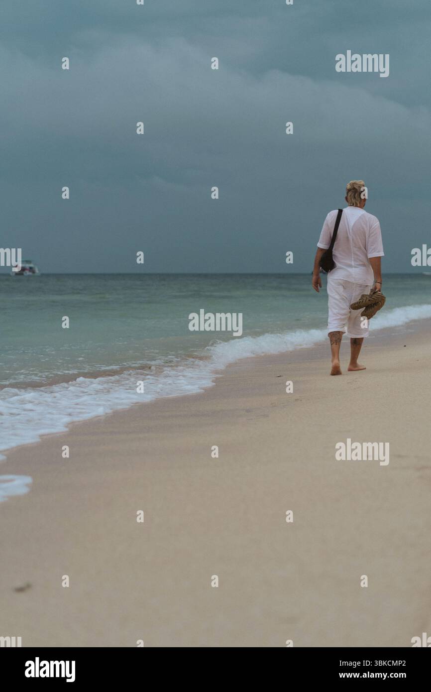 Man walking barefoot along seashore hi-res stock photography and images ...