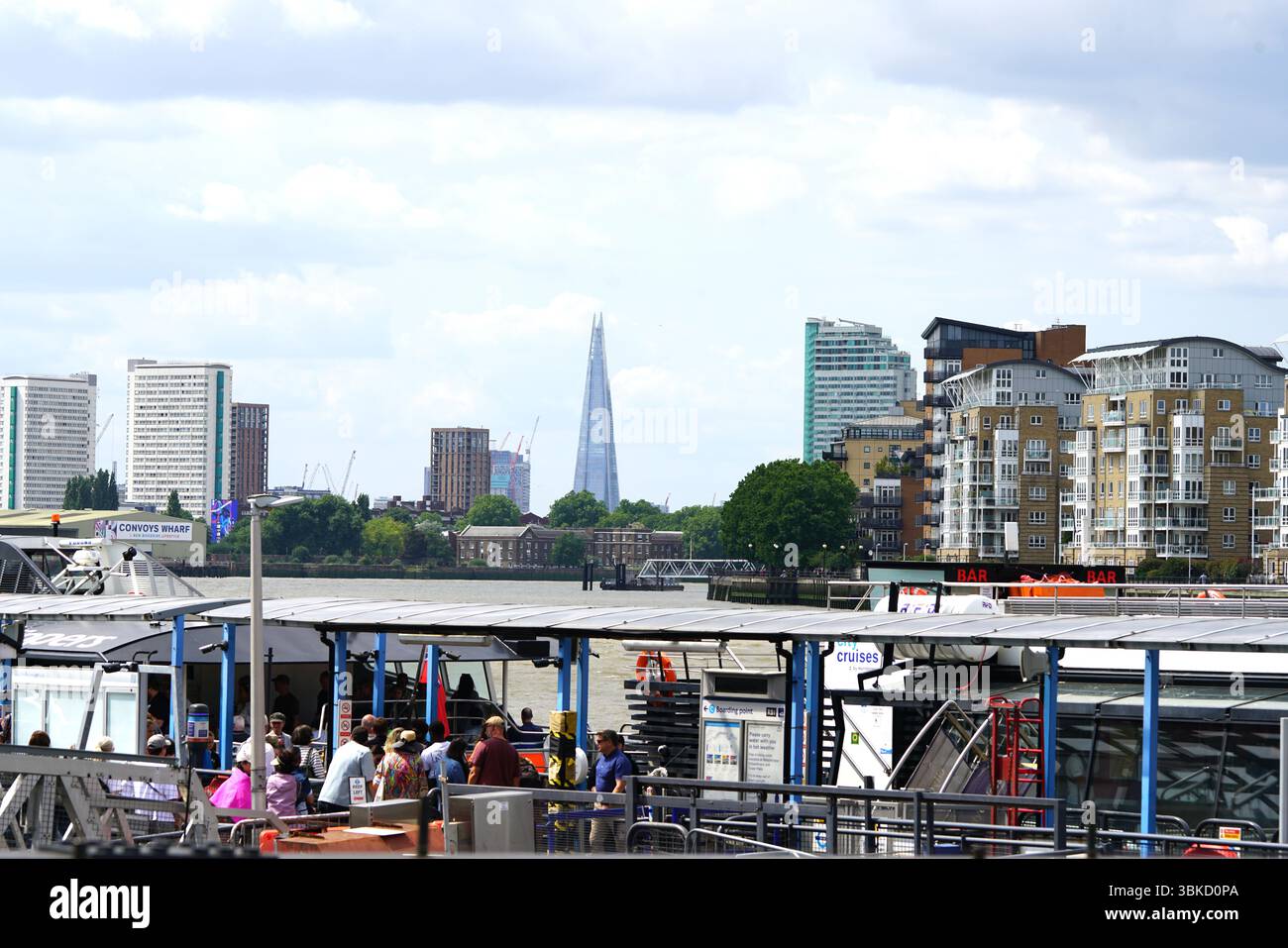Busy Riverside Scene with Modern Architecture in Urban Setting under Bright Sky. Greenwich, London, England Stock Photo