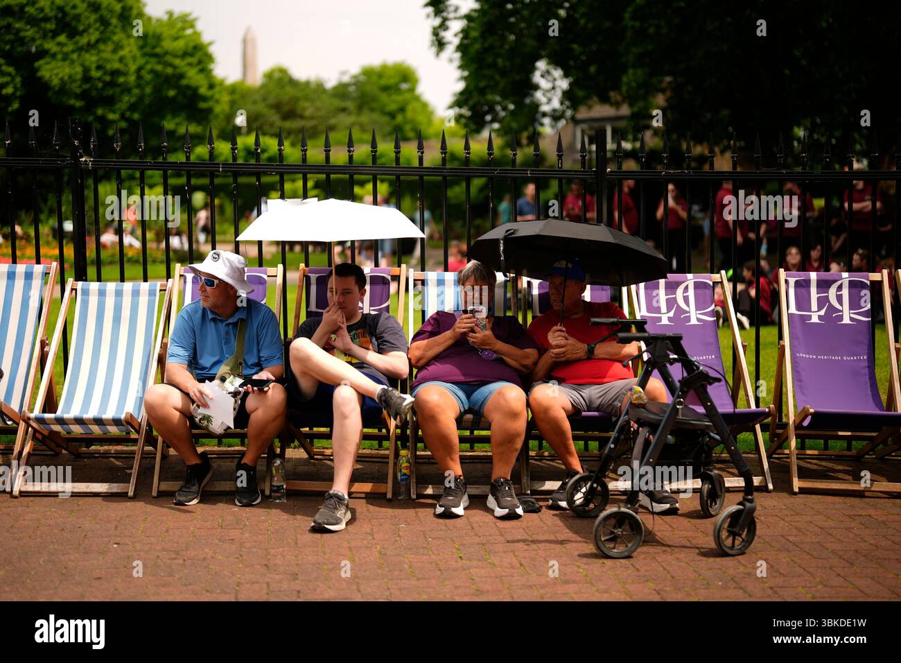 People shield from the sun under umbrellas in Victoria Embankment ...