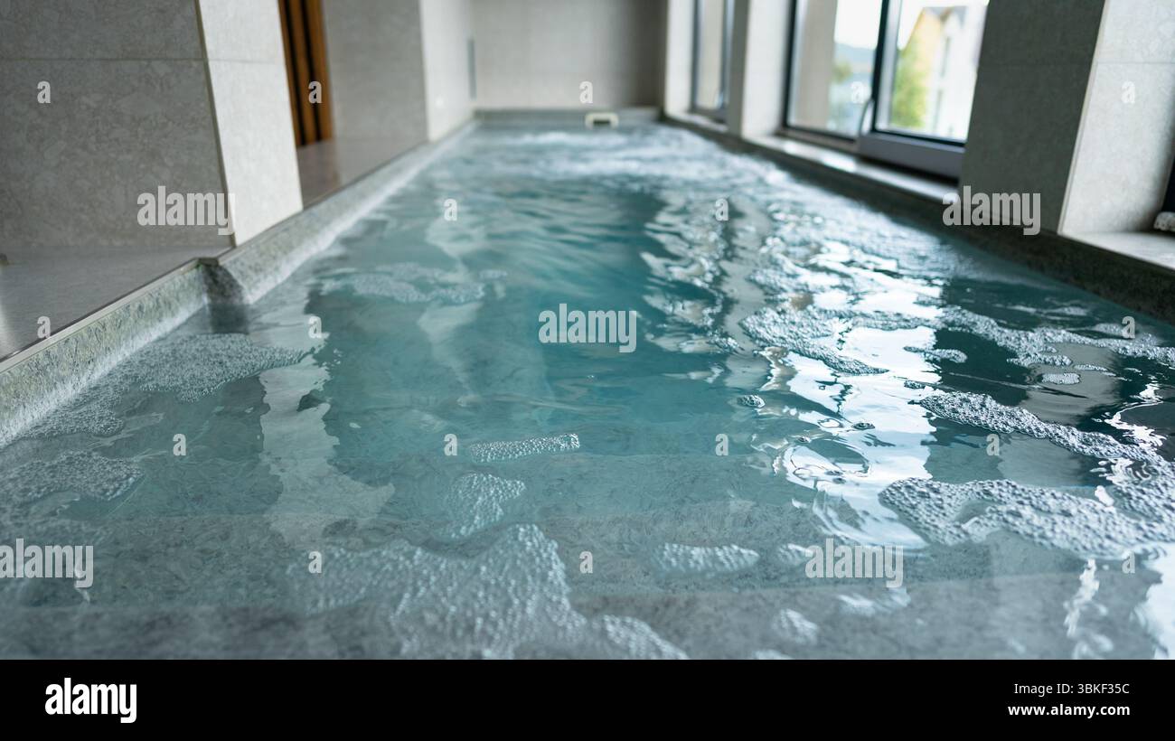 A pool in a spa salon with working high-pressure jets for water massage ...