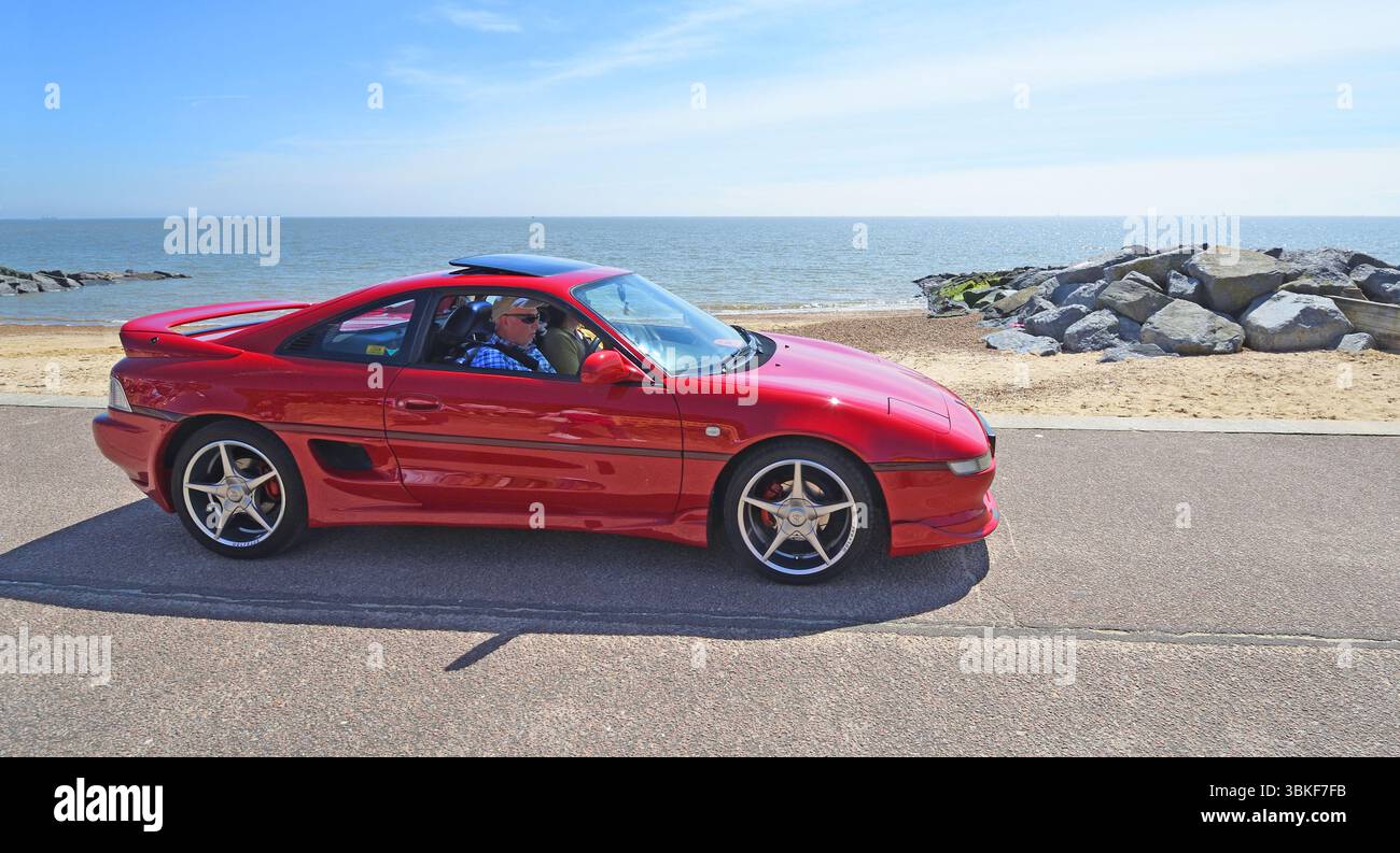 Classic Red Toyota MR2 being driven along seafront Stock Photo - Alamy