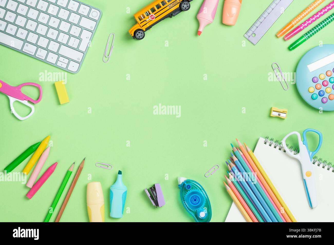 Back to school concept. Flat lay composition with Keyboard and school supplies on green background with copy space. Stock Photo