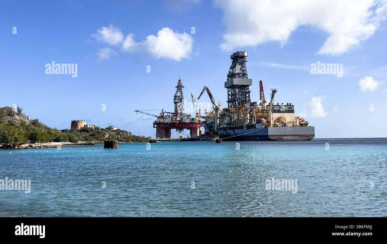 Floating 'La Muralla' a large piece of offshore drilling equipment right next to Drill Ship close to the beach in Caribbean sea in Curaçao Stock Photo