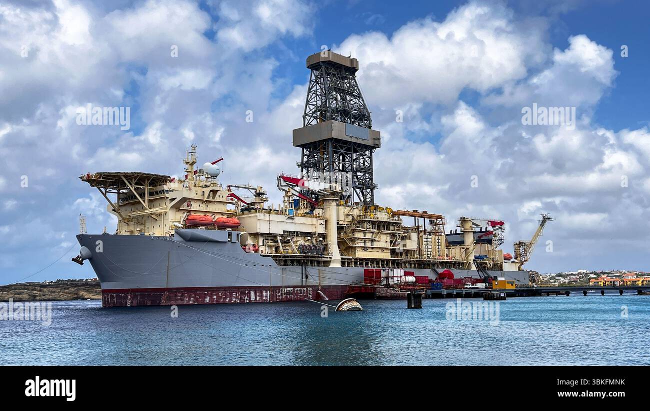 Portrait Drill Ship is called 'NOBLE VOYAGER', while standing close to Caribbean Island Curacao. Ship is drilling for the oil and gas . Stock Photo