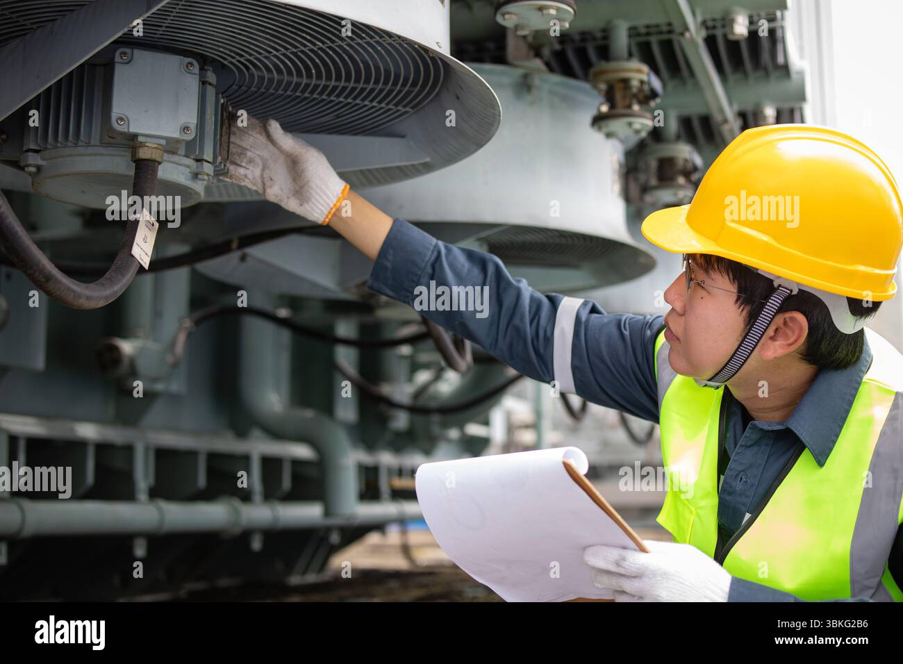 Engineering Check Efficiency Issue An engineer performs inspection on transformer cooling system at ...