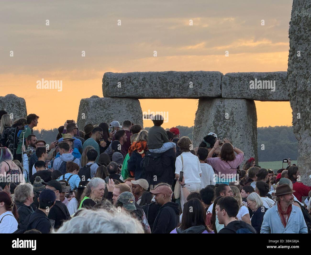 People gather at Stonehenge, Wiltshire, during sunrise on the summer solstice, the longest day of the year. Picture date: Saturday June 21, 2025. Stock Photo