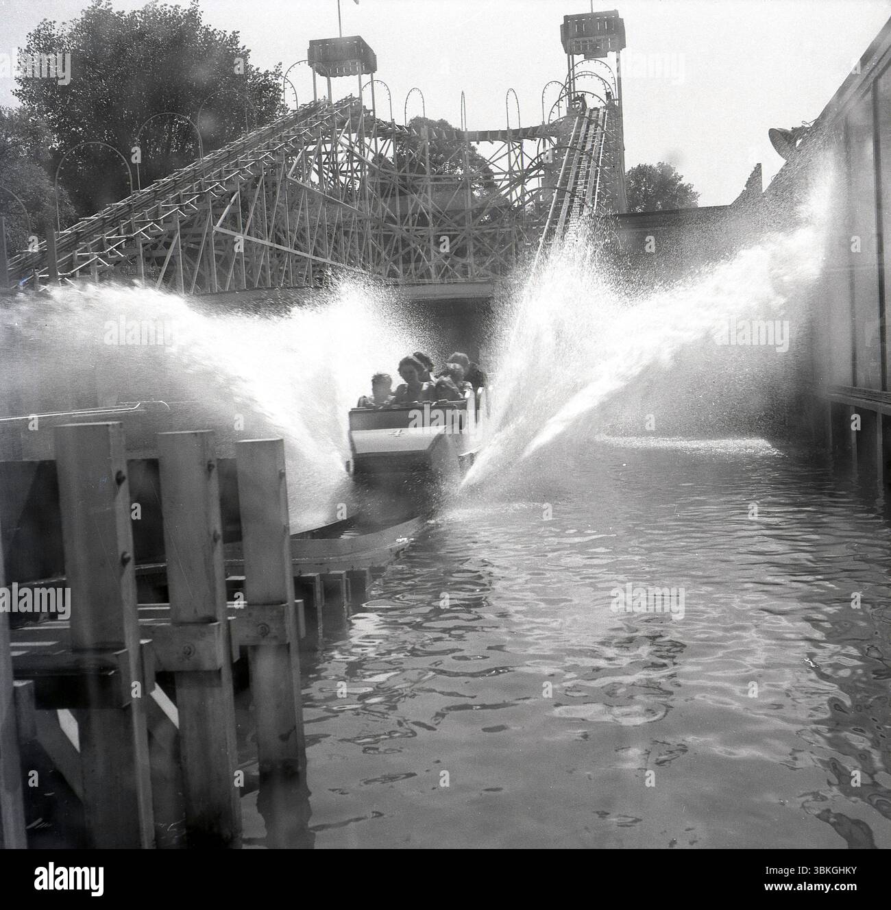1960s, historical, spray coming from a carriage of people on the water ...