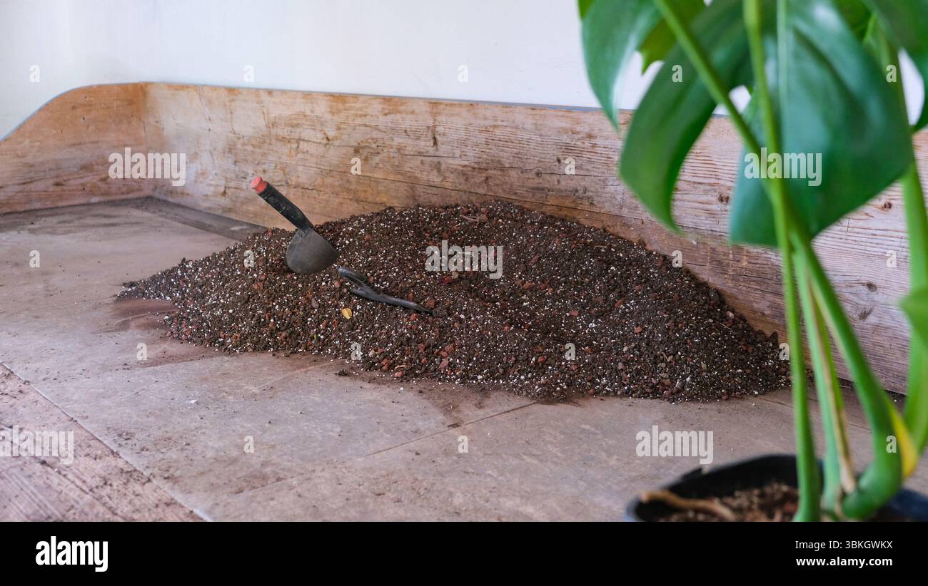 Soil, nutrient substrate and a scoop for transplanting potted plants ...