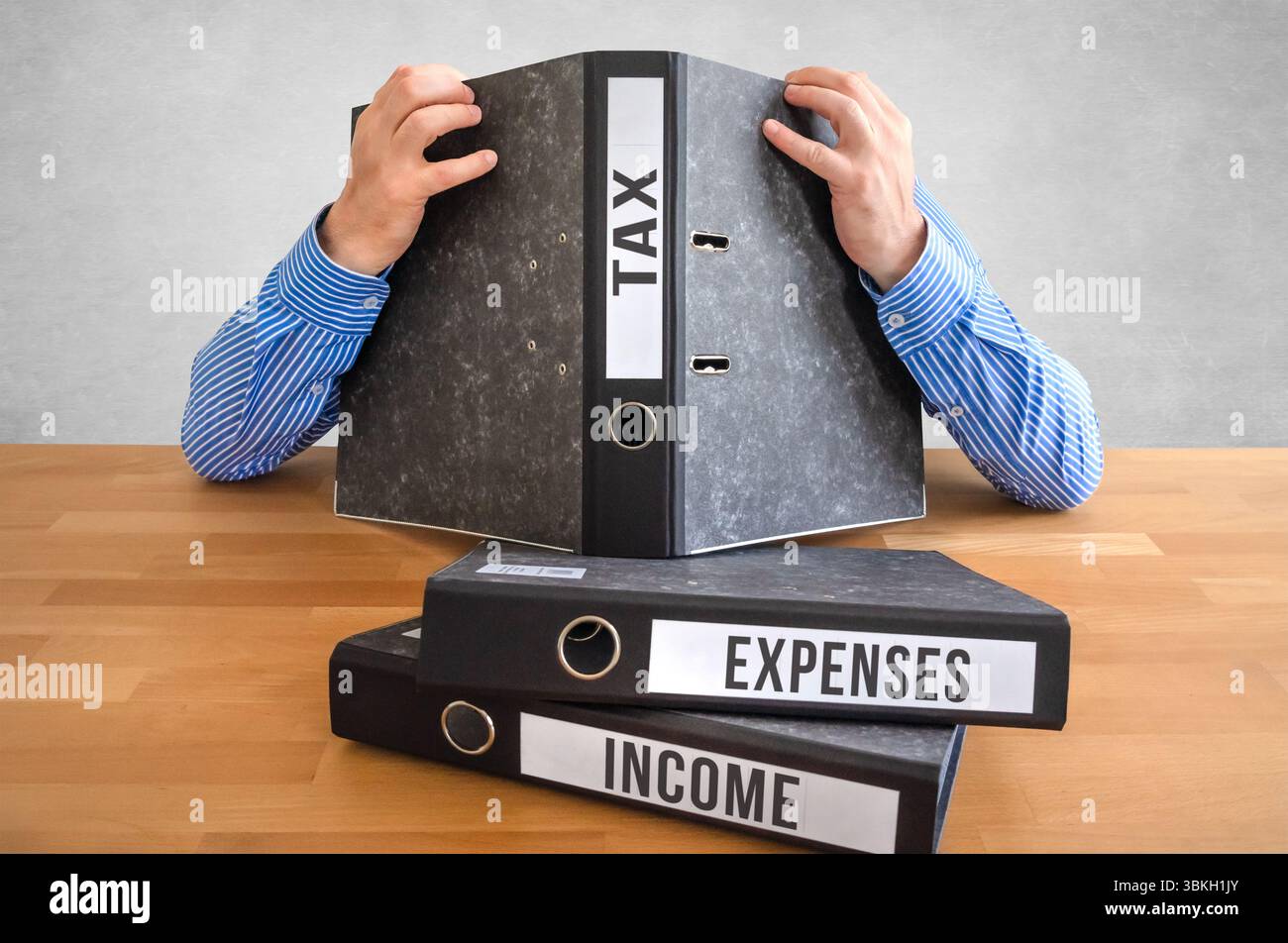 Tax Filing Frustration - Overwhelmed by Paperwork and Deadlines Stock Photo