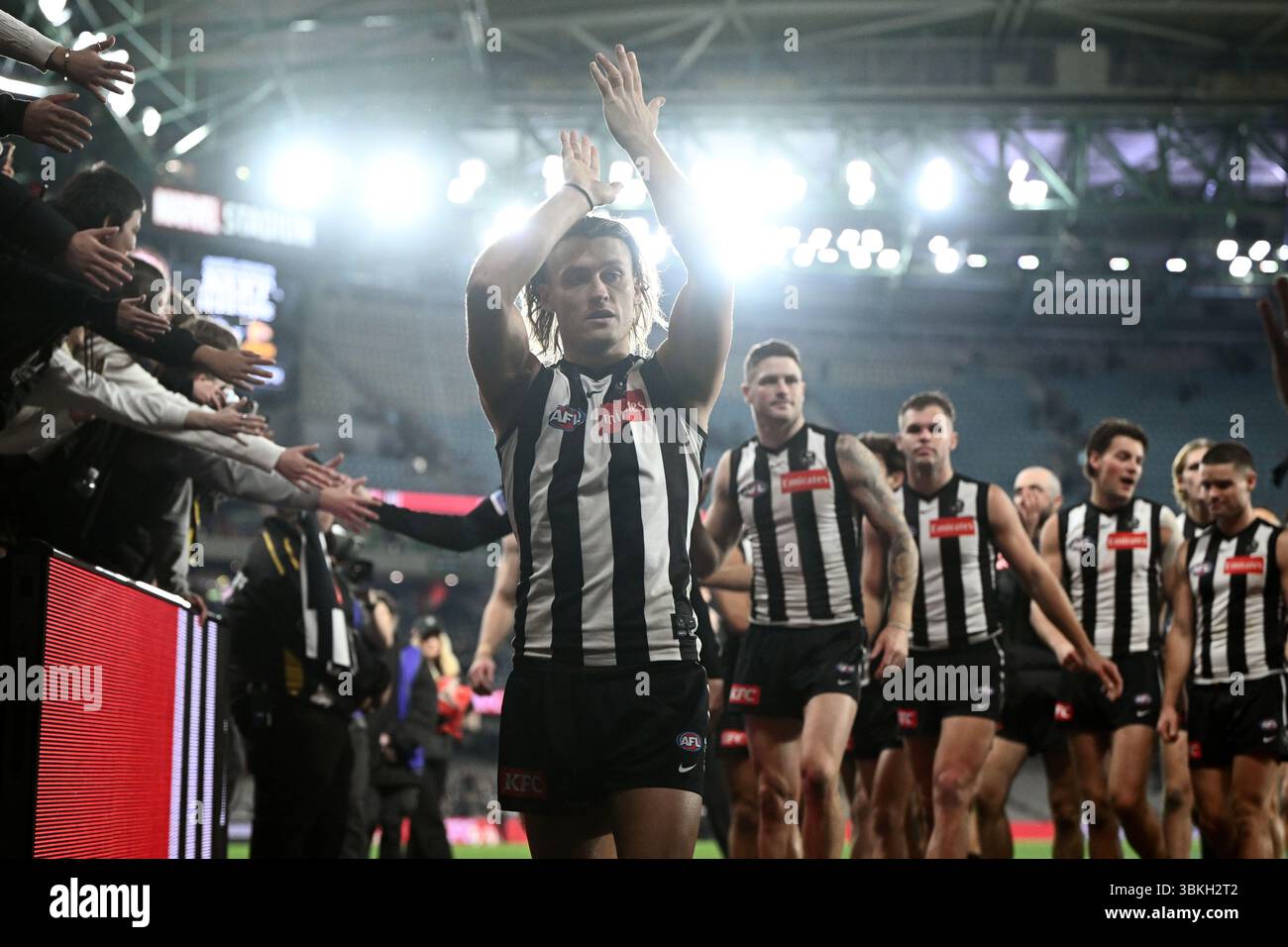 Darcy Moore of Collingwood leads teammates from the field following the