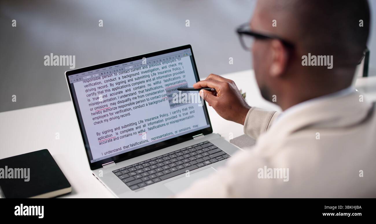 Document Proofreading: African American Man Editing Script Online Spelling Errors Stock Photo