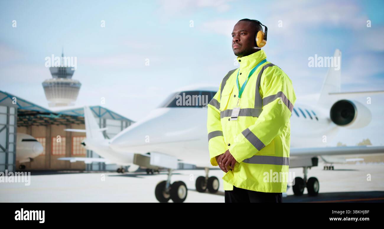 African-American Aircraft Maintenance Engineer In Yellow Uniform Working On Airplane Stock Photo