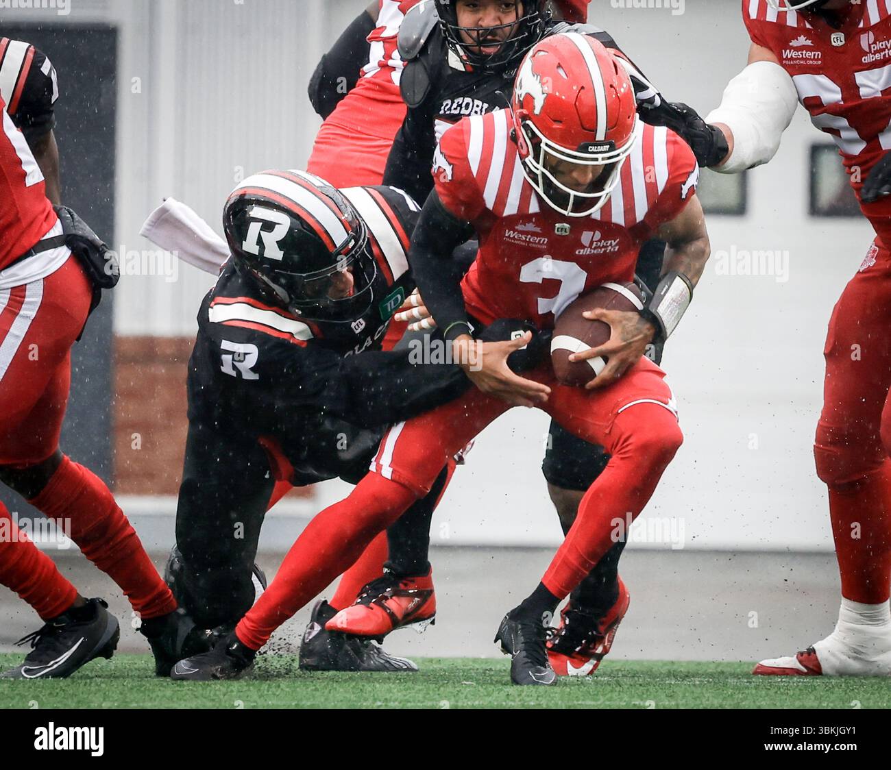 Ottawa Redblacks' Jovan Santos-Knox, left, sacks Calgary Stampeders