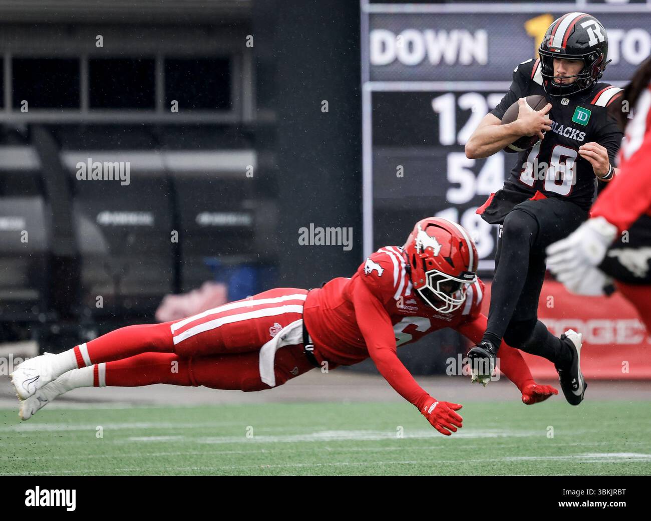 Ottawa Redblacks quarterback Dustin Crum, right, leaps away from