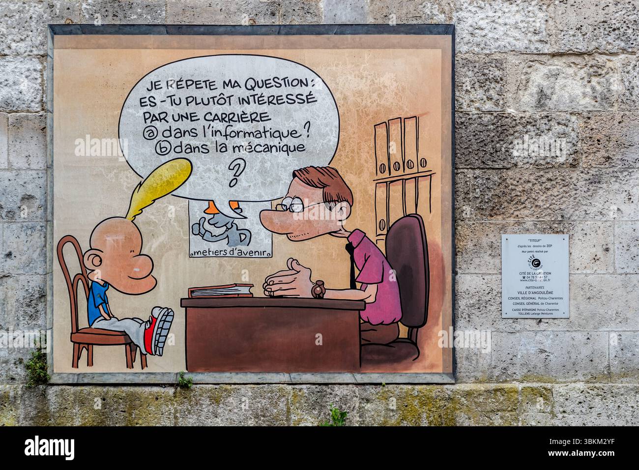 Wall painting depicts a scene from the comic ‘Titeuf’ by Zep. It shows Titeuf being asked by a man in an office whether he is more interested in a career in IT or mechanics. The mural is part of a project by the Cité de la Création and is supported by the city of Angoulême and other partners. Angoulême is recognized as a UNESCO Creative City in the category of literature since 2019. Rue du Fort de Vaux, Angoulême, Nouvelle-Aquitaine, France Stock Photo
