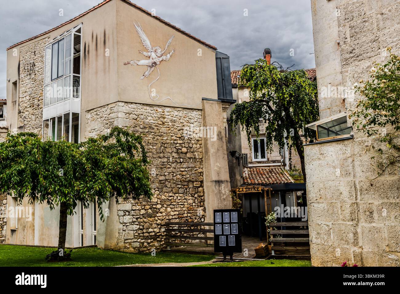 A mural depicts an angel ascending to heaven. The artwork can be seen on the façade of a building and adds an artistic touch to the surroundings. Angoulême is recognized as a UNESCO Creative City in the category of literature since 2019. Rue Saint-André, Angoulême, Nouvelle-Aquitaine, France Stock Photo