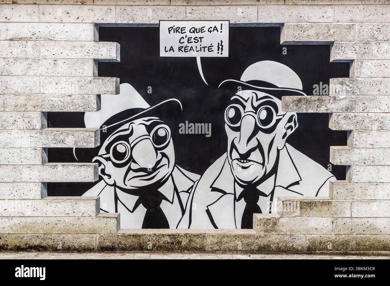 Mural in the Rue de Beaulieu in Angoulême, France, Nouvelle-Aquitaine, Europe. The artwork shows comic figures that seem to burst out of the wall, with speech bubbles containing sentences in French. It is part of the ‘Réalité, Sortie de Secours’ (Reality, Emergency Exit) series designed by Marc-Antoine Mathieu and realised by Cité de la Création. Angoulême is recognized as a UNESCO Creative City in the category of literature since 2019. Rue de Beaulieu, Angoulême, Nouvelle-Aquitaine, France Stock Photo