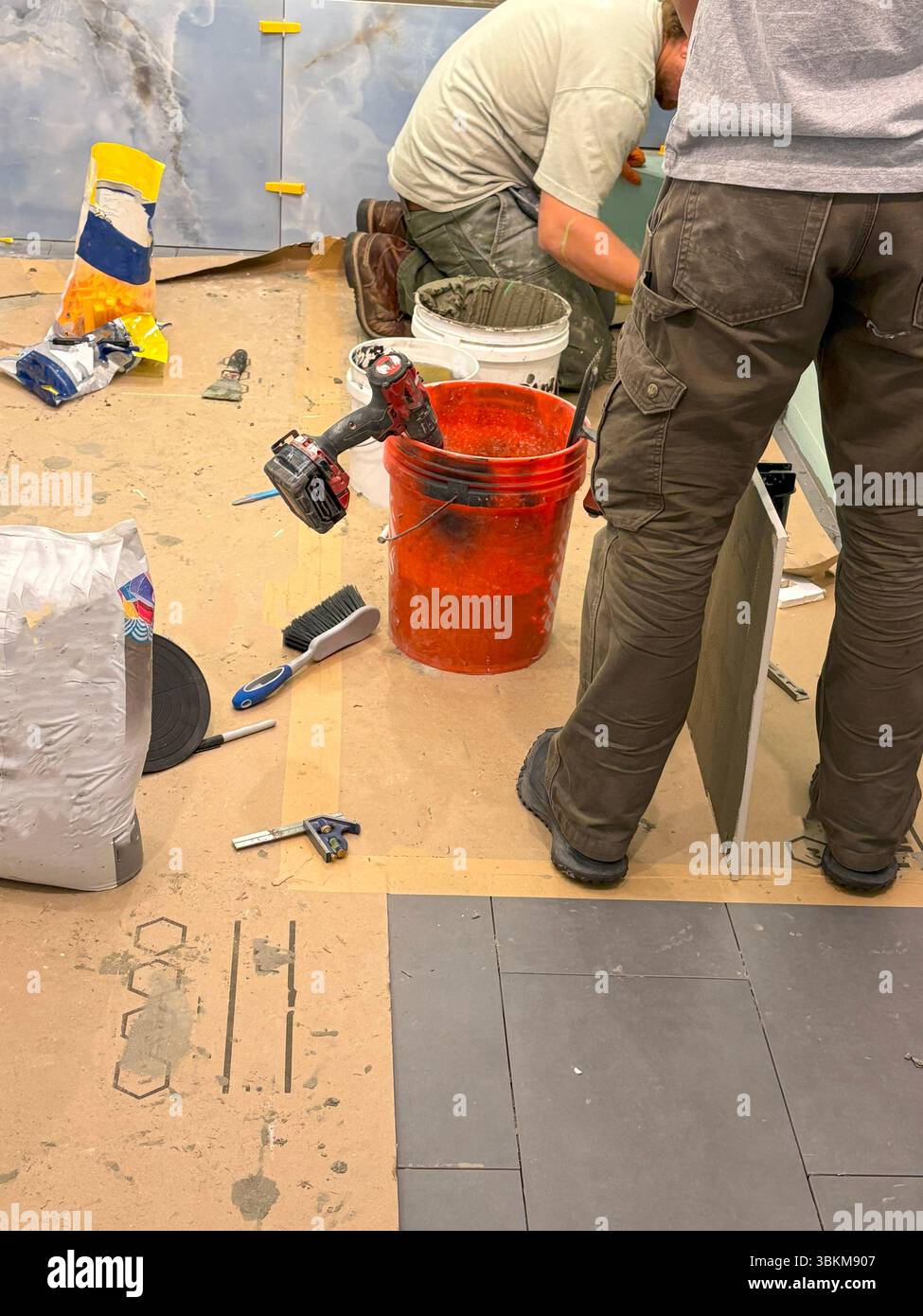 Two construction workers focus on details while working on a renovation project. Stock Photo