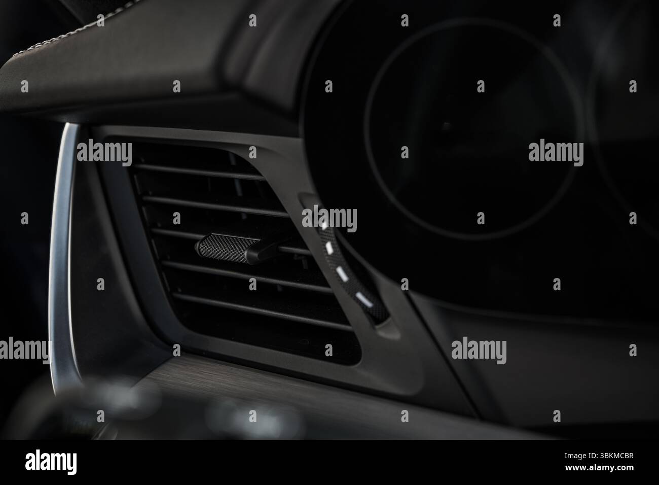 Close-up of a sleek car interior featuring an air vent and control knobs, showcasing modern automotive design and functionality. Stock Photo