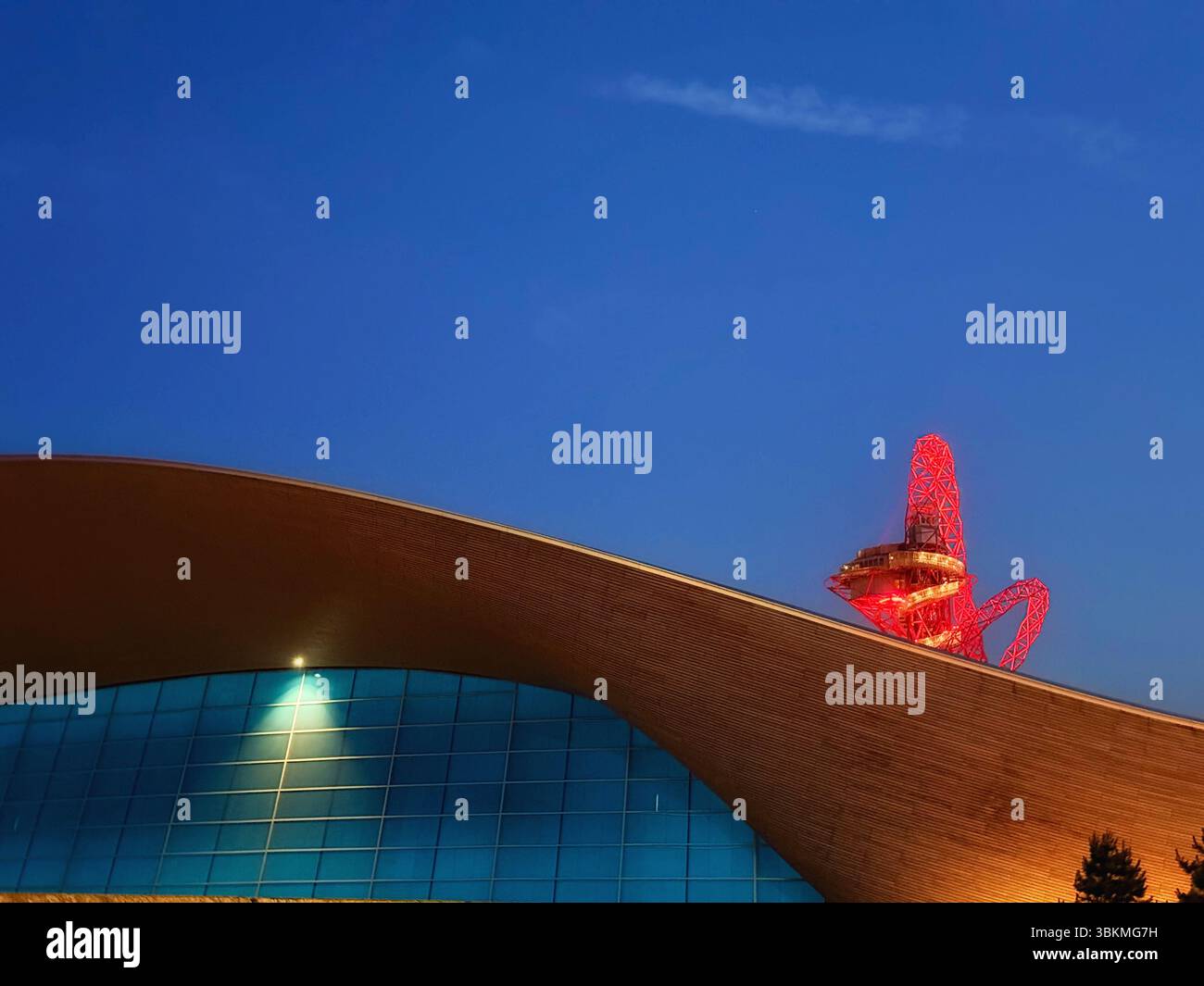 London Aquatics Centre with ArcelorMittal Orbit at dusk lit up in red at the Queen. Elizabeth Olympic Park in Stratford, London. - Smartphone Captured Stock Image