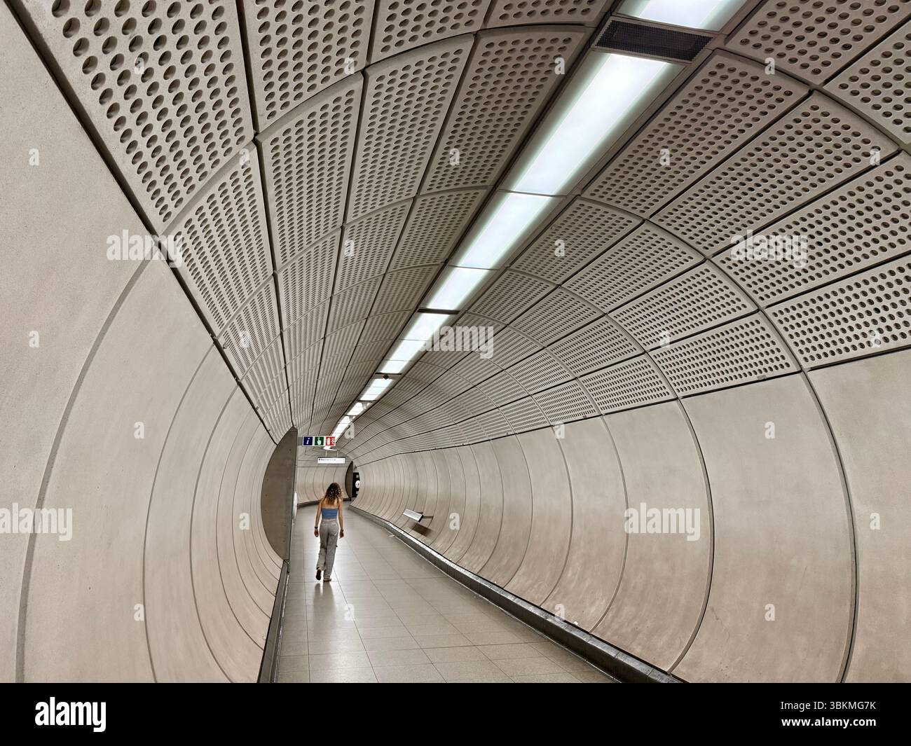 Pedestrian tunnel with woman alone walking. connecting Liverpool Street and Moorgate underground tube stations. - Smartphone Captured Stock Image
