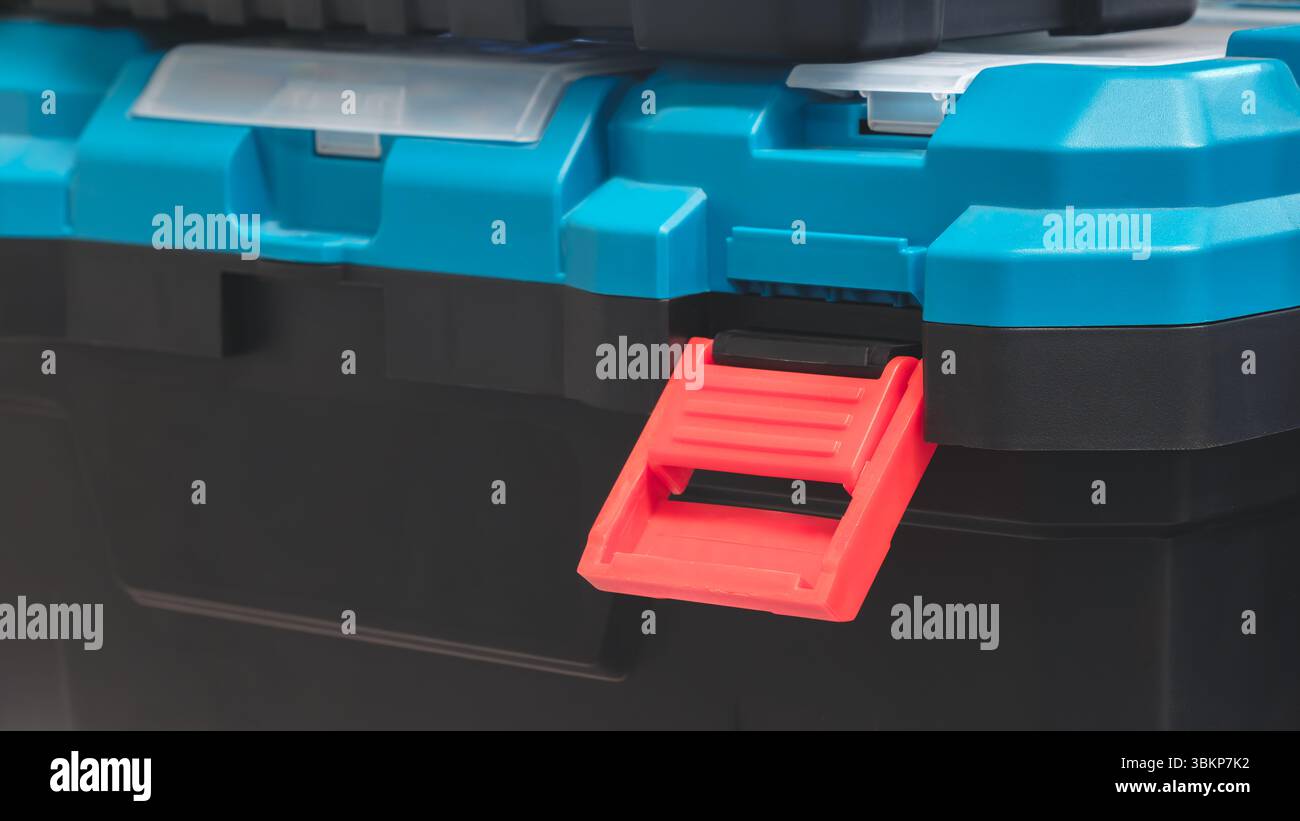 Black Plastic Tool Box with Blue Lid with Open Red Lock Stock Photo