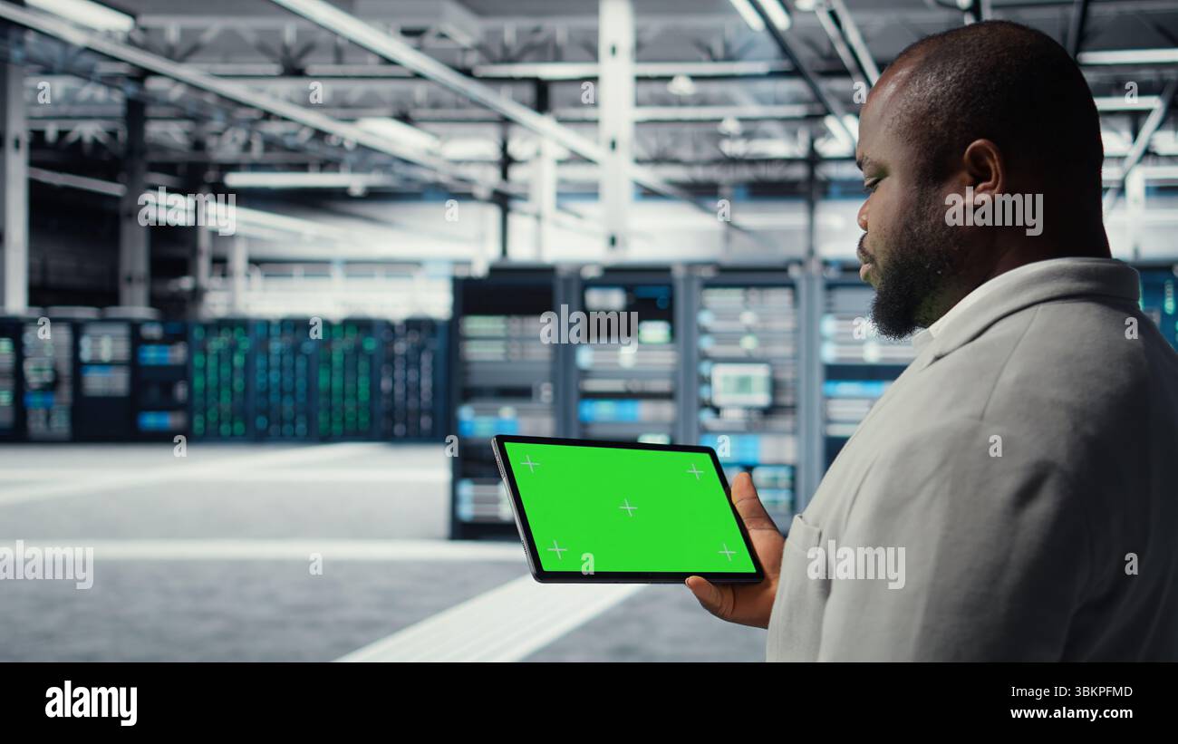 Engineer in data center using green screen tablet to develop disaster ...