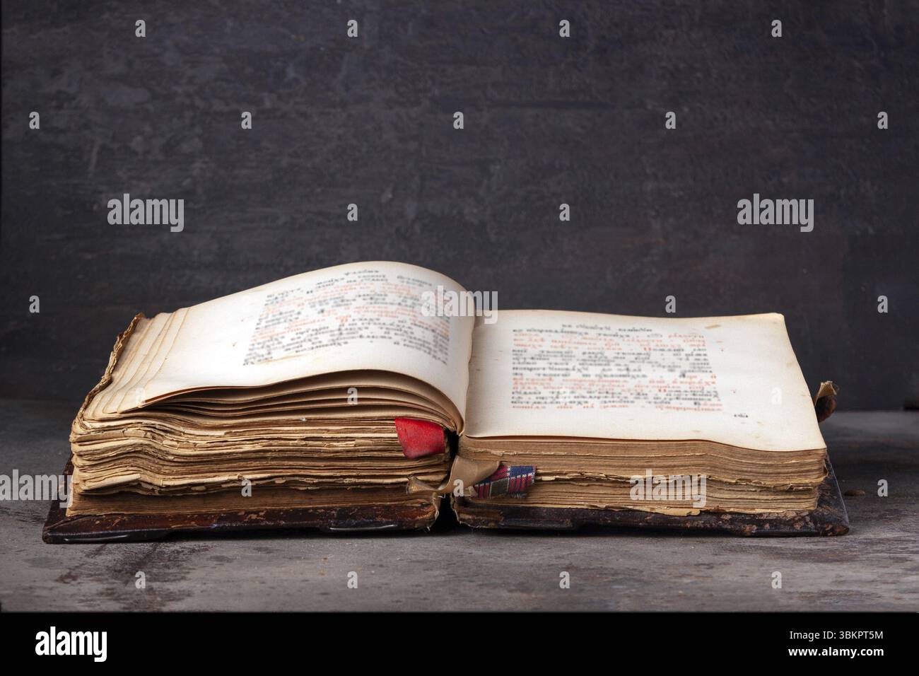 An open old leather-bound book on a dark background Stock Photo